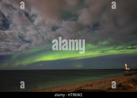 Aurora sopra il faro sulla Gardskagi, Keflavik, Islanda Foto Stock