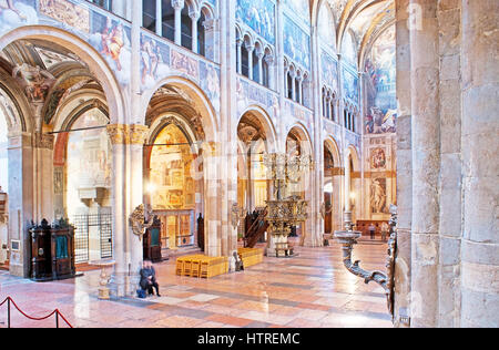 PARMA, Italia - 24 Aprile 2012: la navata centrale del Duomo separata dalle navate con pilastri di pietra e decorata con affresco medioevale e scolpito Foto Stock