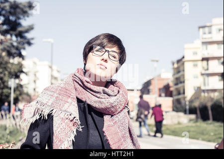 Giovane bella donna outdoor urbano in posa di fronte con gli occhi chiusi al sole Foto Stock