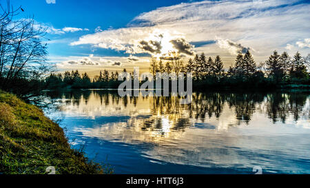 Sunset over Derby e raggiungere il canale di Bedford, un braccio laterale del fiume Fraser, visto da Brae Isola presso la storica cittadina di Fort Langley in BC Foto Stock