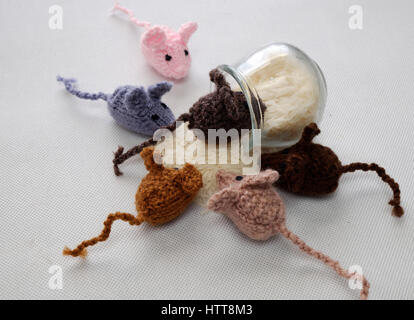 Strano concetto dal prodotto artigianale, gruppo di piccoli topi mangiano riso, splendidi animali giocattoli per bambini, ratti a maglia lavorato a maglia di filati Foto Stock