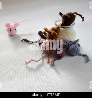 Strano concetto dal prodotto artigianale, gruppo di piccoli topi mangiano riso, splendidi animali giocattoli per bambini, ratti a maglia lavorato a maglia di filati Foto Stock