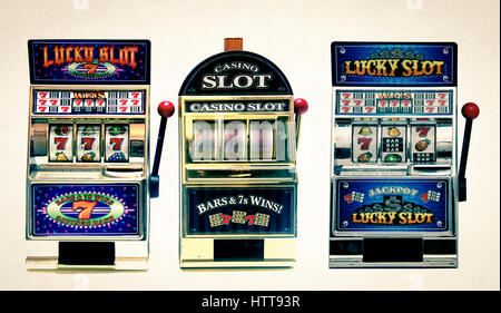 Tre giocattolo vintage slot machines con denaro in oro Foto Stock