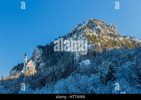 Il Castello di Neuschwanstein sulla mattina presto in inverno circondato da ombre Foto Stock