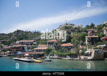 SIMENA, Turchia - 20 maggio : Kalekoy Simena insediamento in Uchagiz Baia dei Turchi nei pressi di città sommersa di Kekova con case stonebuilt miscelato con antica rovina Foto Stock