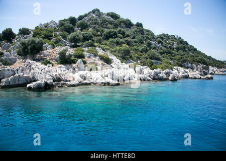 Antica città sommersa di kekova nella baia di uchagiz villaggio nella provincia di Antalya in Turchia con montagne coperte da arbusti sempreverdi chiusa in giornata soleggiata p Foto Stock