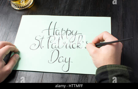 Maschio di scrittura di un felice St Patrick giorno scheda di calligrafia Foto Stock