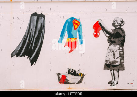 Batumi, Adjara, Georgia. Street graffiti dal Dottor amore con la Nonna appendere gli abiti abiti di supereroi - Batman è impermeabile, Superman e vestiti Foto Stock