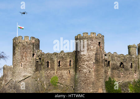 Conwy Castle con bandiera gallese e piccolo drone volare al di sopra. Conwy, Wales, Regno Unito, Gran Bretagna, Europa Foto Stock