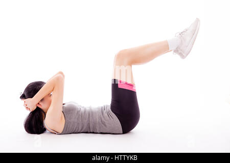 Asian ragazza adolescente facendo situps su sfondo bianco Foto Stock