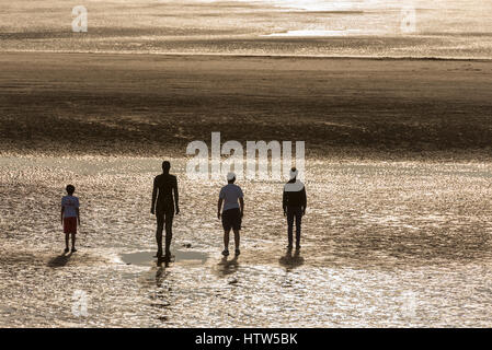 Un altro luogo di Antony Gormley Crosby statue spiaggia tramonto Foto Stock