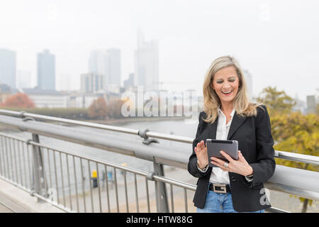 Imprenditrice con tavoletta su un ponte Foto Stock