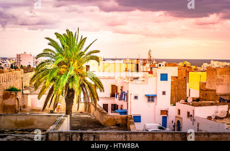 Una strada nella Medina di Sousse, Tunisia. Spazio magico della città medievale con le pareti colorate di verde e di alberi di palma. Foto Stock