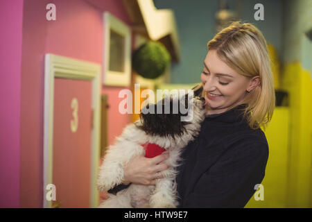 Donna che trasportano papillon cane a cane care center Foto Stock