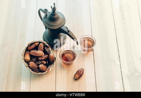 Il tè nero è servita in un Arabo tradizionali coppe con date di dolci. Medio Oriente rituale tè e cibo. Foto Stock