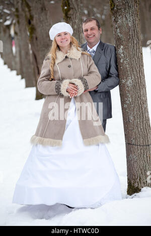 Ritratto a figura intera di amorevole sposi in abito nuziale in winter park Foto Stock