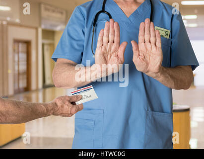 Senior medico in scrubs rifiutando Tessera Medicare Foto Stock