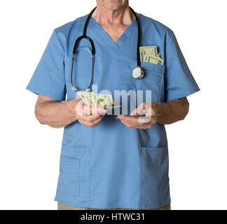 Senior medico in scrubs Conteggio contanti Foto Stock