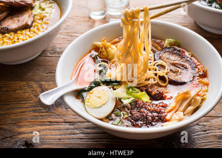 Vista orizzontale di spaghetti ramen essendo tirata da bacchette. Foto Stock