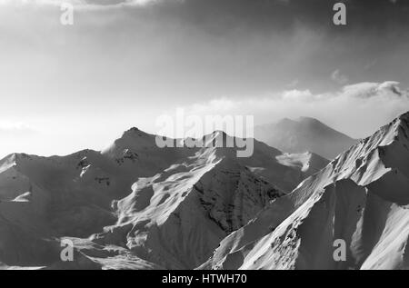 Visualizzazione bianco e nero sulla luce solare innevate montagne in inizio di mattina di nebbia. Montagne del Caucaso, Georgia, regione Gudauri. Foto Stock