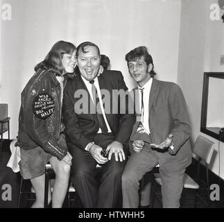 Anni sessanta storico, American rock and roll singer Bill Haley con una giovane femmina la ventola dell'angeli selvaggi e mal grigio, Londra, Inghilterra Foto Stock