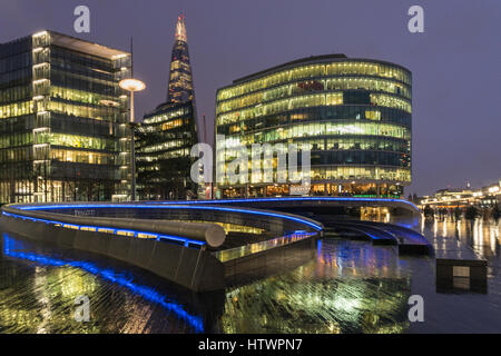 Viste della Shard in umido meteo pioggia all'aperto con riflessioni sui marciapiedi in serata nella Città di Londra Foto Stock