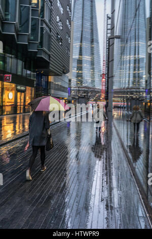 Signora precipitando da con ombrello in caso di pioggia nella città di Londra vista della Shard Foto Stock