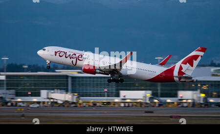 Air Canada Rouge piano aereo Boeing 767 (767-300ER) wide-body jet aereo di linea prendere decollare al crepuscolo crepuscolo dall'Aeroporto Internazionale di Vancouver Foto Stock