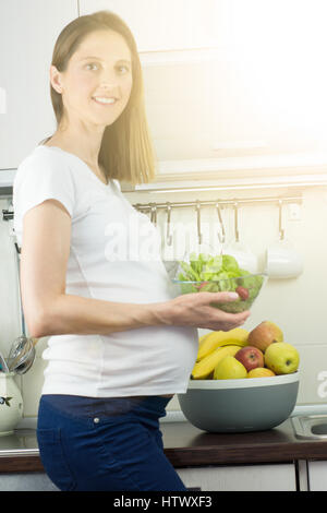 Una sana alimentazione e gravidanza. della donna incinta, pancia e insalata di verdure. Foto Stock
