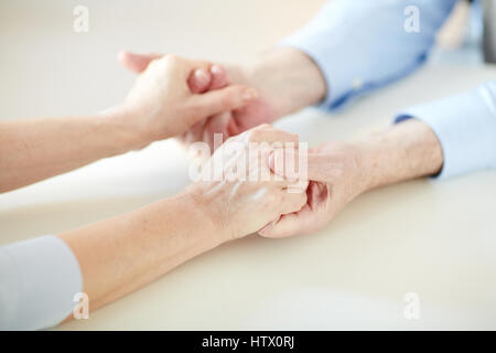 Closeup ritratto di un irriconoscibile matura coppia amorevole cura e supporto di ogni altro, tenendo le mani in momenti di difficoltà Foto Stock