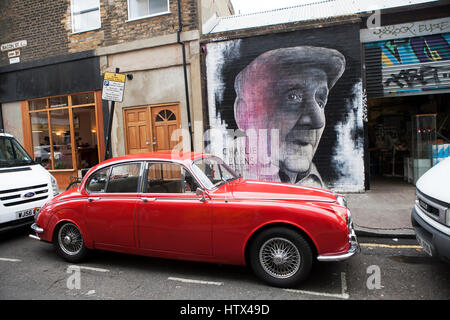 Londra, Inghilterra - Luglio 12, 2016 un murale per uomo locale, Charlie Burns, che gestiva la Repton boxing club di Londra.s est. Vintage auto rossa Foto Stock