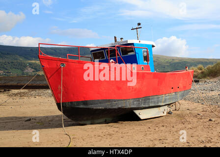 Una barca che si siede sul Barmouth Sands, Barmouth, Galles, Europa Foto Stock