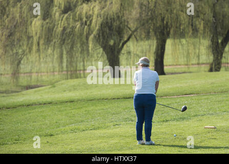 Senior lady golfista prende uno swing Foto Stock