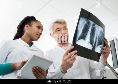 I radiologi con raggi x utilizzando digitale compressa in ospedale Foto Stock