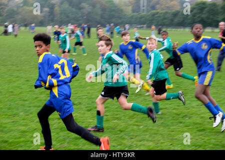 Ragazzi della scuola che giocano a calcio in un parco il sabato mattina REGNO UNITO KATHY DEWITT Foto Stock