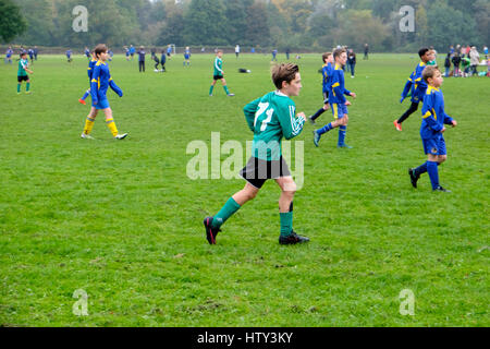 Ragazzi che giocano a calcio in un parco il sabato mattina UK KATHY DEWITT Foto Stock