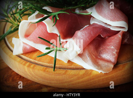 Fette di prosciutto su un tagliere Foto Stock