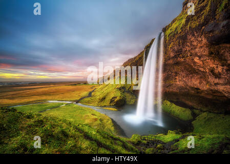 Cascata Seljalandsfoss in Islanda al tramonto. Lunga esposizione. Foto Stock