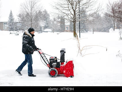 Uomo che utilizza un snow macchina soffiatrice in Canada Foto Stock