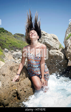 Donna in piedi nel surf gettando la testa indietro, Bolonia beach, Tarifa, Cadice, Andalusia, Spagna Foto Stock