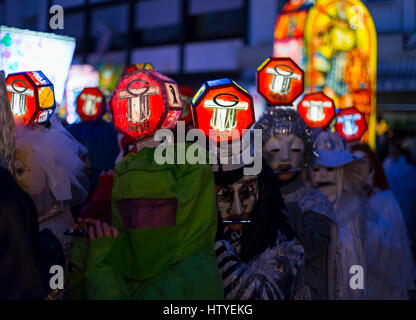 Il Carnevale di Basilea. I partecipanti del carnevale con testa illuminata lanterne giocando piccolo il lunedì mattina per le strade durante la parata Morgestraich. Foto Stock