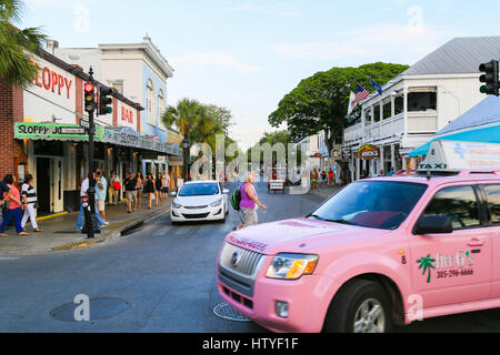 Key West, Stati Uniti d'America - 18 Maggio 2016: l'occupato da Duval Street con il famoso Joes Sloppy Bar nella parte anteriore e di numerosi negozi e ristoranti nel retro. Una rosa è taxi Foto Stock