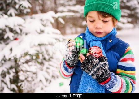 Ragazzo tenendo le decorazioni di Natale Foto Stock