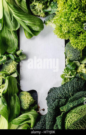 Varietà di materie vegetali verdi insalate, lattuga, cavolo cinese, mais, broccoli, cavolo verza come cornice rotonda bianca vuota tagliere. Sfondo di cibo. T Foto Stock