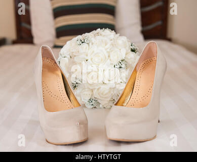 Primo piano dettaglio di alta nuziale piattaforma con tacco stiletto scarpe matrimonio con bouquet di fiori Foto Stock