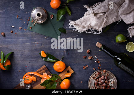 Arance con foglie, nocciole e il vino su una tavola di legno. Spazio libero per il testo . Vista dall'alto. Foto Stock