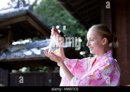 La donna caucasica indossare uno yukata in casa tradizionale giapponese Foto Stock