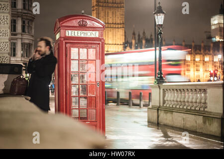 Uomo al telefono vicino al telefono rosso scatola in Londra - Regno Unito Foto Stock