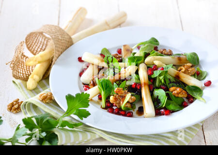 Asparagi bianchi su la valeriana con canditi di noci, semi di melograno e aceto balsamico Foto Stock