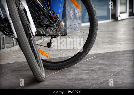 Dettaglio di due moderne biciclette ruote su un marciapiede grigio sfondo Foto Stock